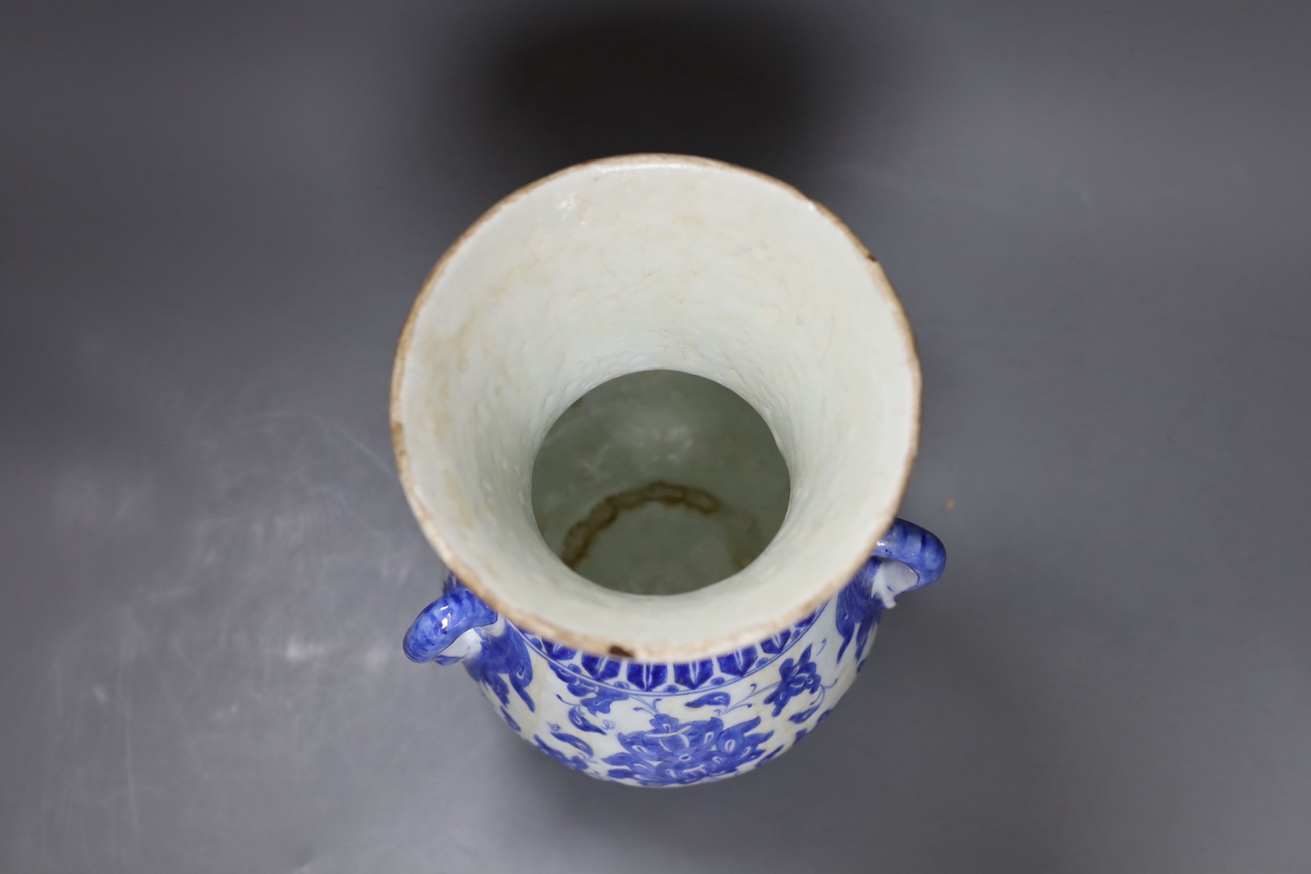 A three-handled blue and white Iznik pottery vase with floral motif, 22.5cm tall